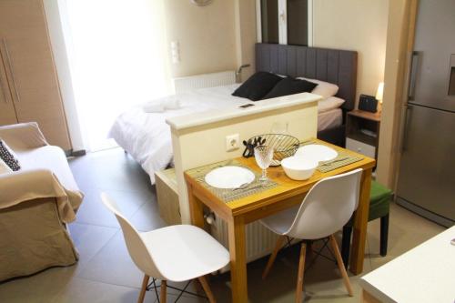 Habitación pequeña con mesa, sillas y cama en AIOLOS VOULA near the sea apartment en Atenas