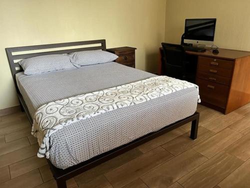 a bedroom with a bed and a dresser and a television at Los Tres Pinos in Guatemala