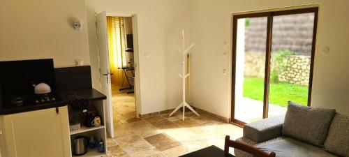- un salon avec un canapé et une porte en verre dans l'établissement T-2est 46m dons la maison au bord du Canal du Midi, à Saint-Hilaire-de-Lusignan