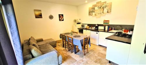une cuisine et un salon avec un canapé et une table dans l'établissement T-2est 46m dons la maison au bord du Canal du Midi, à Saint-Hilaire-de-Lusignan