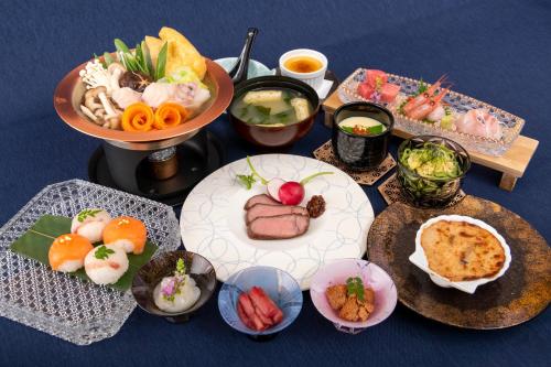 una mesa con platos de comida y tazones de comida en みくに隠居処, en Sakai