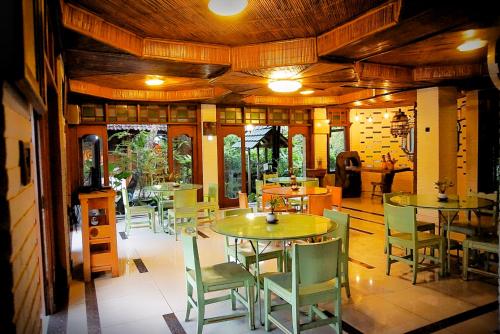 un ristorante con tavoli e sedie in una stanza di Ary's Hotel by Cocotel a Yogyakarta