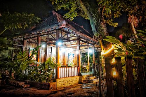 a small house with lights in a garden at night at Ary's Hotel by Cocotel in Yogyakarta