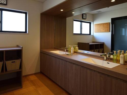 uma casa de banho com um lavatório grande e um espelho grande em みくに隠居処 em Sakai