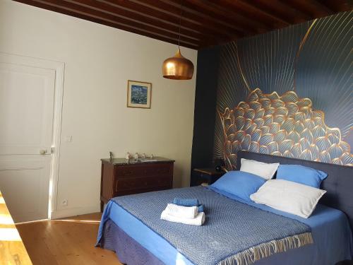 a bedroom with a blue bed with a blue and gold headboard at Villa Colin, la tête dans les bois, à deux pas de la mer, classée 4 étoiles in Yport