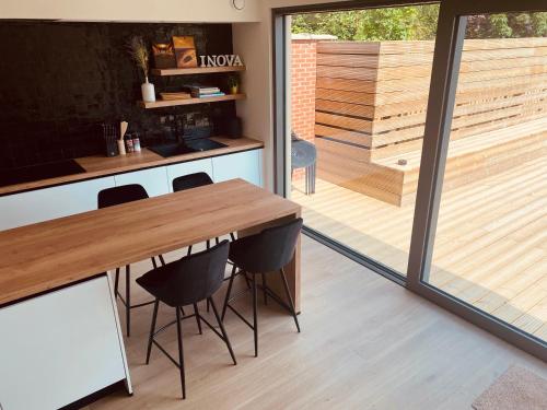 een keuken met een houten tafel en zwarte stoelen bij Inova Guesthouse in Hasselt