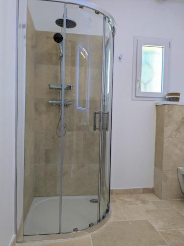une douche avec une porte vitrée dans une salle de bain dans l'établissement Les pierres dorées, à Saint-Maurice-sur-Eygues