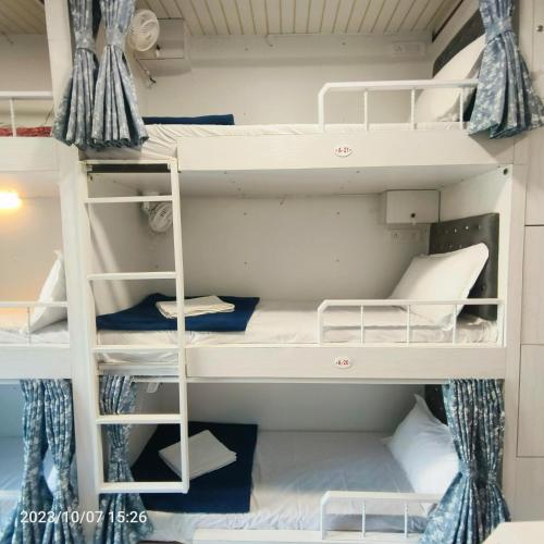 a bunk bed in a room with white bunk beds at Marol Metro Dormitory in Mumbai