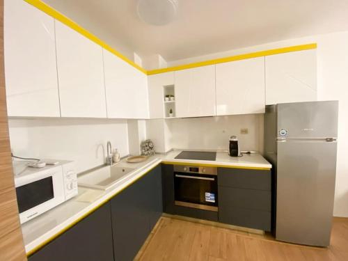 a kitchen with white cabinets and a stainless steel refrigerator at Maryland Apartment in Sofia