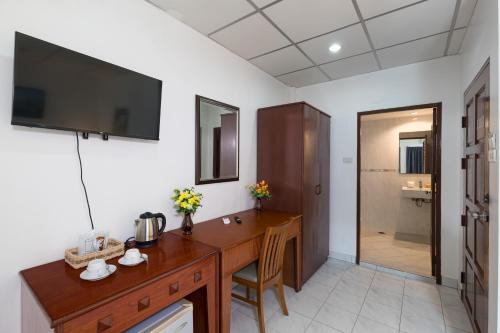 a room with a wooden desk with a television on the wall at Bevans Place Karon in Karon Beach