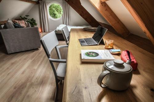 a wooden table with a laptop computer on top of it at Het Rooversnest in Riel