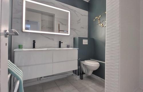 a bathroom with a white sink and a toilet at La Kaz à MaLou appartement de standing avec piscine et plage à 800m in Les Trois-Îlets