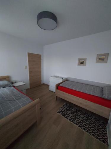 a bedroom with two beds and a lamp on the wall at Haus Anton 