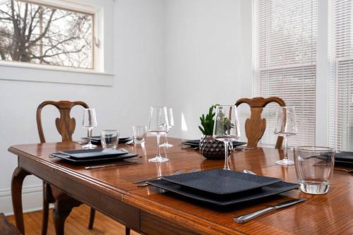 a wooden table with wine glasses on top of it at King Bed - 5 Min to MOA - 75 & 65' HDTV - Ping Pong in Richfield
