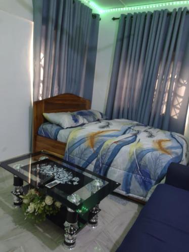 a bedroom with a bed and a glass table at Kingee Lodge in Sunyani