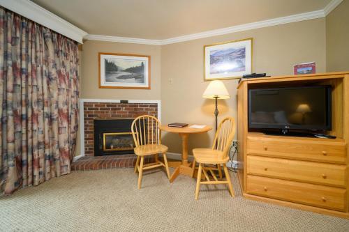 a living room with a table and chairs and a fireplace at Stoweflake Mountain Resort & Spa in Stowe