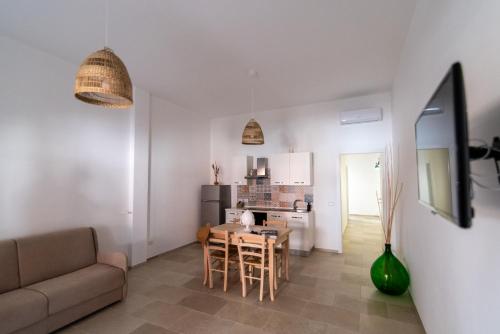 un soggiorno e una cucina con tavolo e divano di Il casalicchio for families a Montalbano