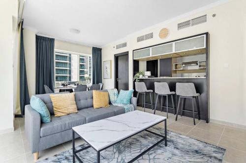 a living room with a couch and a kitchen at StoneTree - Stylish 2BR with Dubai Marina Canal View in Dubai