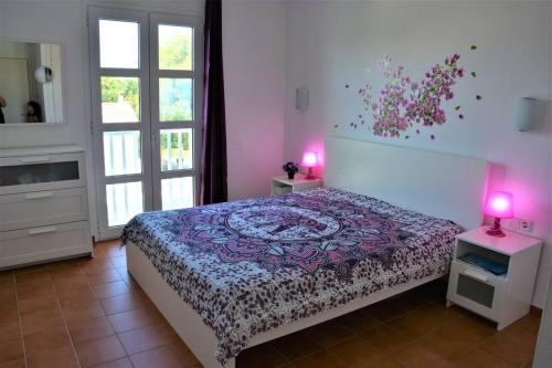 a bedroom with a bed and two lamps and a window at Son Xoriguer appartement calme, mer, piscines.Son Xoriguer quiet apartment, sea, swimming pools. in Son Xoriguer