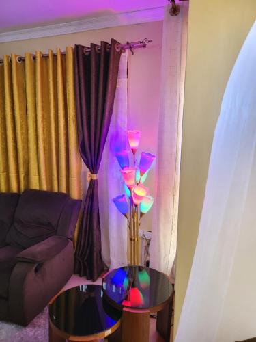 a living room with a table with a lamp on it at G&G Homes Eldoret in Eldoret