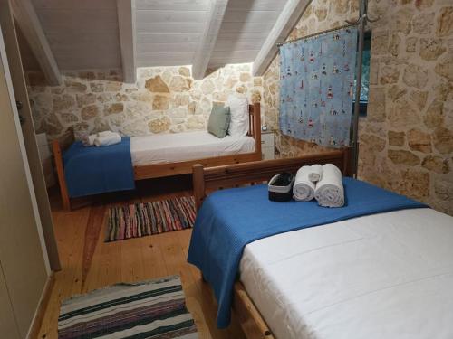 a bedroom with two beds and a stone wall at Villa VaKo in Vathí