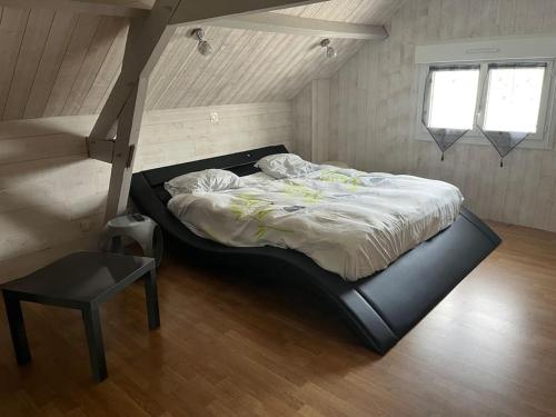 een slaapkamer met een groot bed op zolder bij Villa Lenotre in Bourges