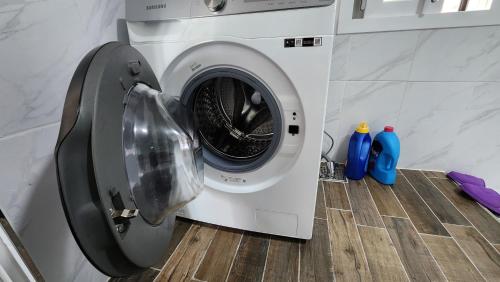 a washing machine with its door open in a kitchen at Jeju stay Jeong in Seogwipo