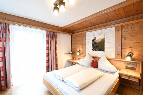 Schlafzimmer mit einem großen Bett und Holzwänden in der Unterkunft Vermunt 19a in Galtür