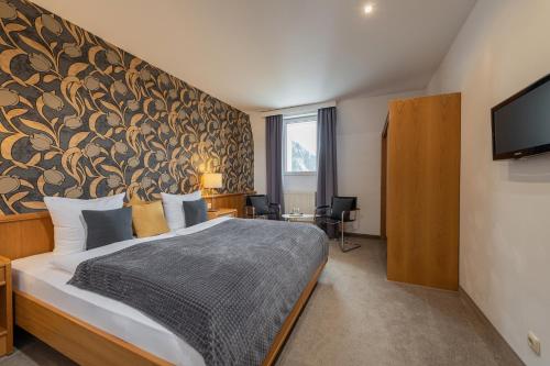 una camera da letto con un grande letto con un grande muro di Hotel Rader a Bad Gastein