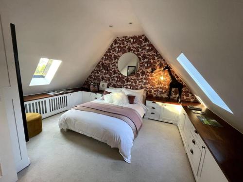 a bedroom with a large bed in a attic at 18th Century Converted Coach House 
