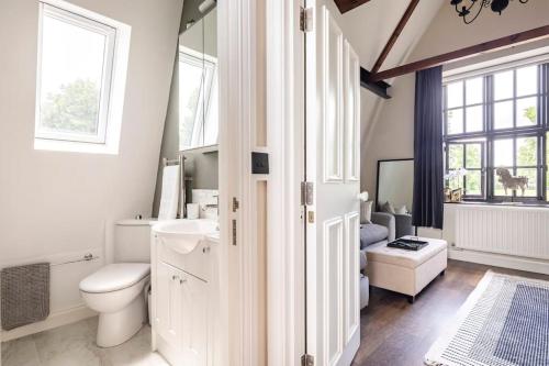 a white bathroom with a toilet and a sink at 18th Century Converted Coach House 