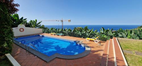 a swimming pool with the ocean in the background at Sunny Arco Retreat in Arco da Calheta