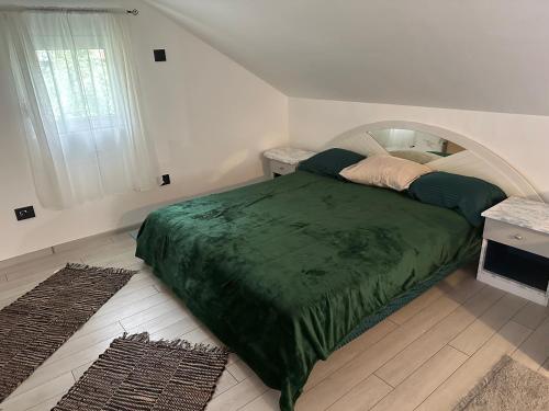 um quarto com uma cama com um edredão verde em Matesevo Home em Mateševo