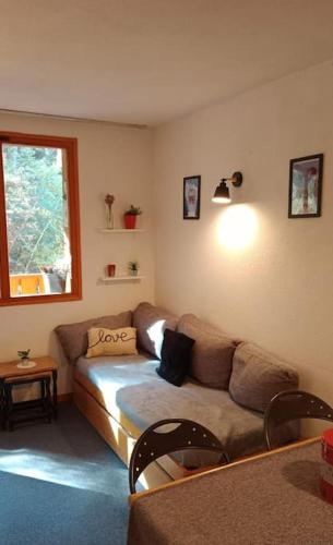 uma sala de estar com um sofá e uma janela em Superbe appartement à Valfréjus em Valfréjus