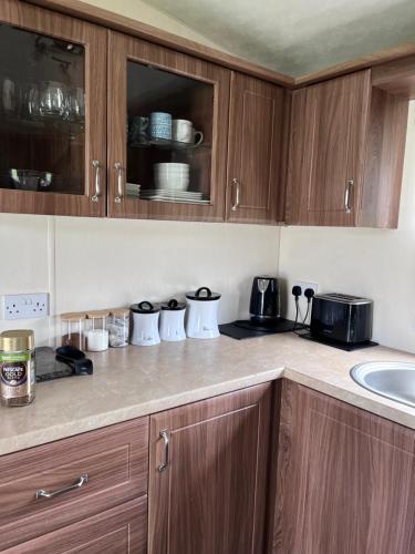 a kitchen with wooden cabinets and a counter top at Bird Lake Pastures in Great Billing