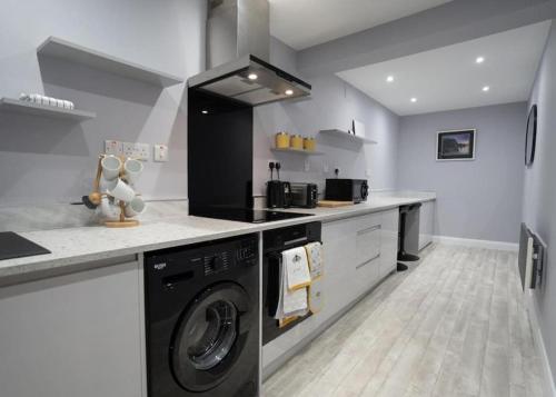 a kitchen with a washer and dryer in it at Stay Indigo in Ballycastle