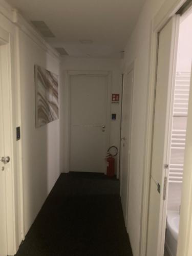 a hallway with a white door and a red suitcase at Brignole Rooms in Genova
