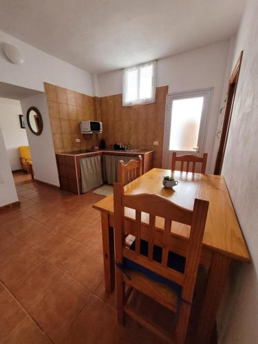Casa Natalia. في Taibique: مطبخ وغرفة طعام مع طاولة وكراسي خشبية