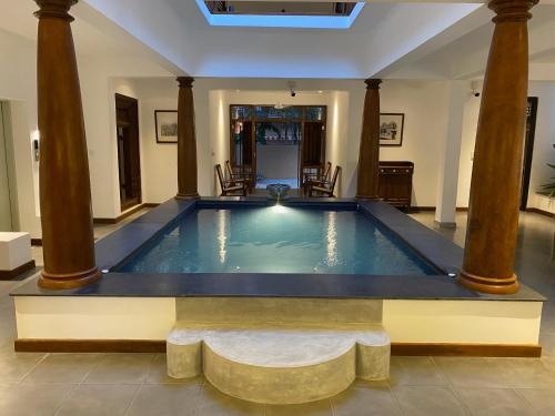a swimming pool in a room with columns at The Mango Nest in Jaffna