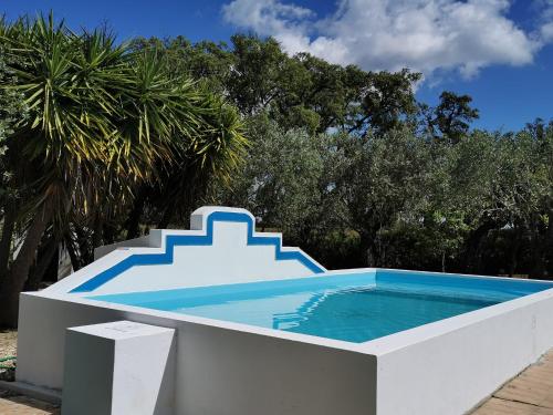a swimming pool with a staircase on top of it at Montadinho Houses in São Bartolomeu da Serra