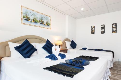 two beds with blue and white pillows in a room at Bevans Place Karon in Karon Beach