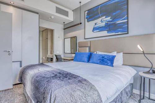 a bedroom with a large bed with blue pillows at 1 bed Luxury Apartment with pool in Johannesburg