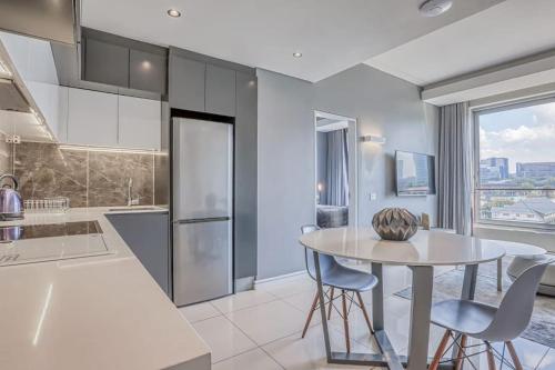 a kitchen with a table and two chairs and a counter at 1 bed Luxury Apartment with pool in Johannesburg