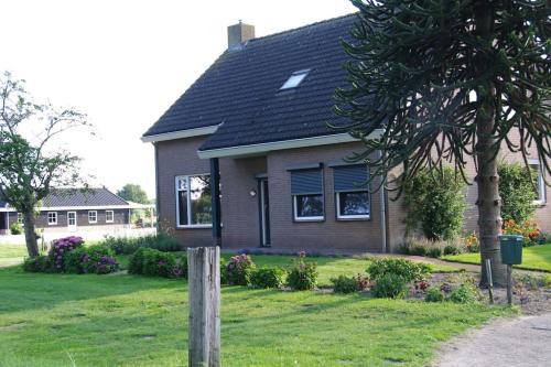 a house with a black roof on a yard at De Morgenzon in Waspik