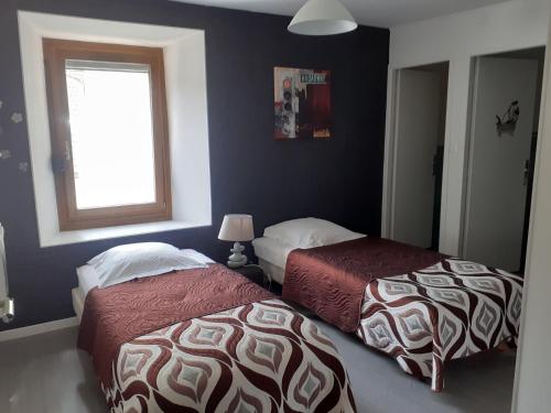 1 dormitorio con 2 camas y ventana en BONSEJOUR, en Saint-Maurice-sur-Moselle