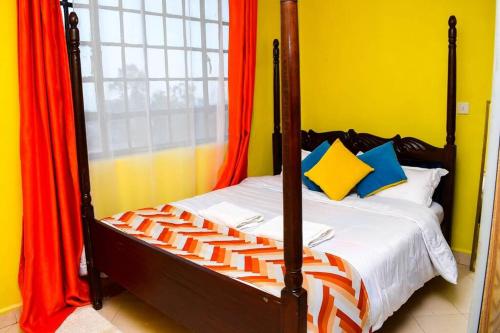 una camera da letto con un letto con cuscini arancioni e blu di EP Home a Meru