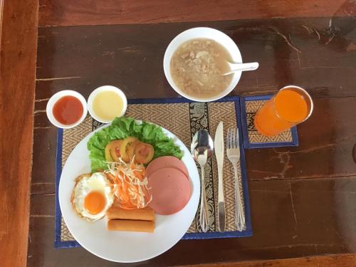 a table with a plate of food and a bowl of soup at เชียงคานพาราไดร์รีสอร์ท&มีตติ้ง 