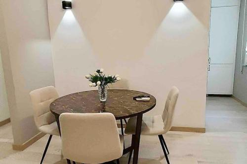 a table with chairs and a vase of flowers on it at Casa nicola- apt in the heart of Rome in Rome