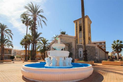 uma grande fonte em frente a um edifício com palmeiras em Los Urrutias, Murcia, Mar Menor em Los Urrutias