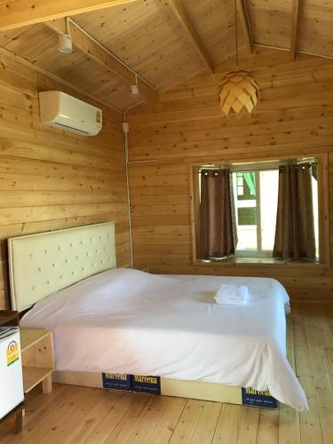 a bedroom with a bed in a wooden room at Sripiamsuk Resort Bangkok in Pathum Thani